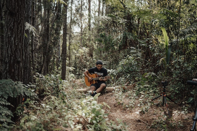 Kit playing guitar in a forest